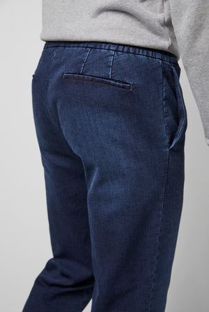 Blue pants worn by a person on a plain background